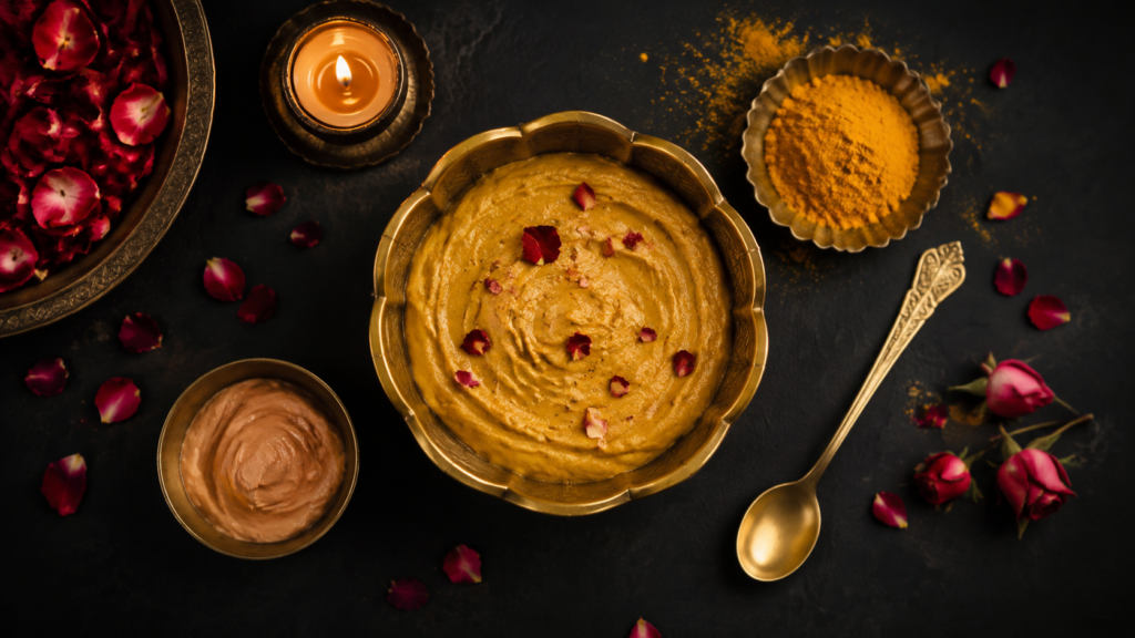 Bridal ubtan bowl with rose petals, turmeric and sandalwood on a dark luxury background